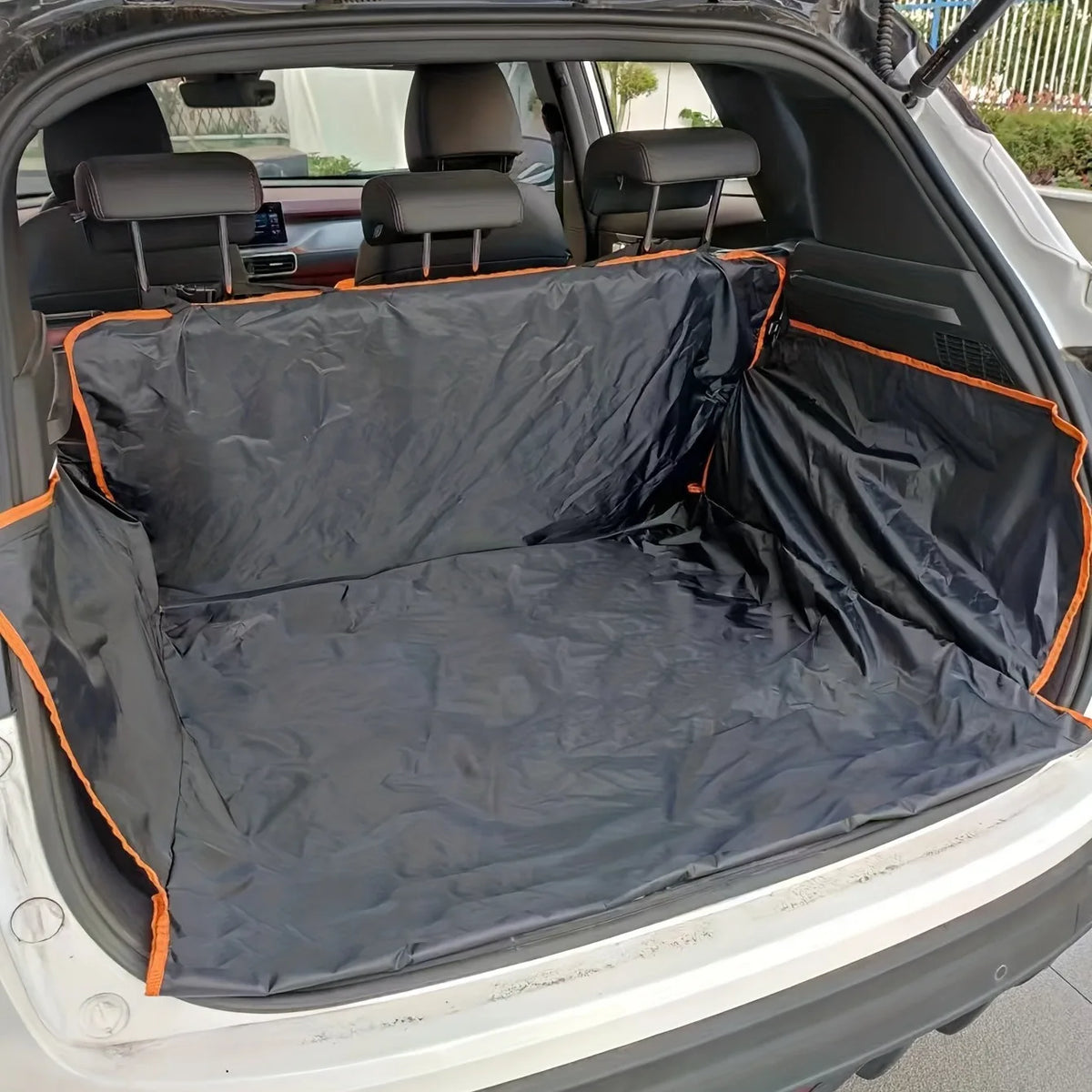 Black waterproof dog car trunk liner with orange trim, protecting SUV cargo space for muddy adventures.